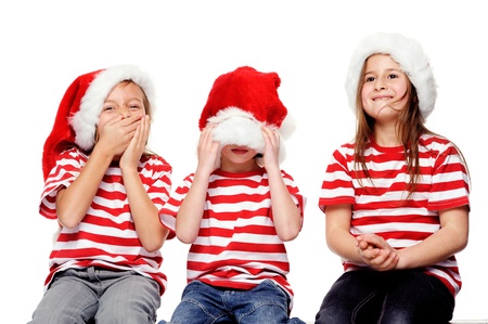 Christmas children having fun with xmas hats, gift box and matching t-shirts isolated on white backgroundの写真素材
