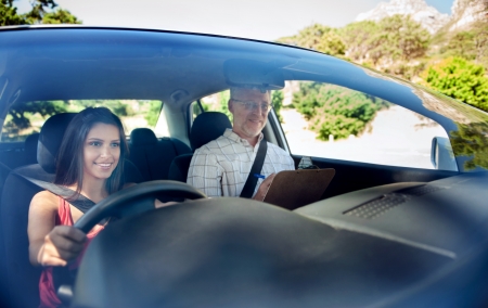 Learner driver student driving car with instuctor. happy and confident smiling girlの写真素材