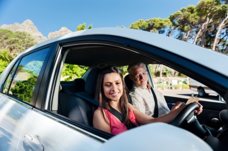 Learner driver student driving car with instuctor. happy and confident smiling girlの写真素材