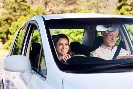 Learner driver student driving car with instuctor. happy and confident smiling girlの写真素材