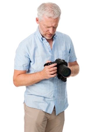 Mature man using digital camera photography hobby isolated on white backgroundの写真素材