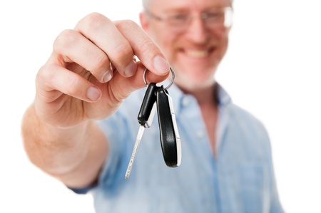 Mature car salesman success handing car keys to new owner