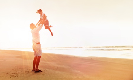 Healthy father and daughter playing together at the beach carefree happy fun smiling lifestyleの写真素材
