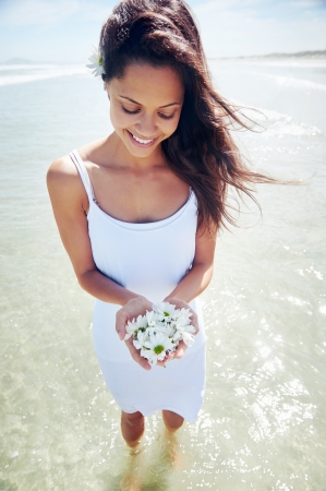 gorgeous woman with daisy flowers portrait at beachの写真素材