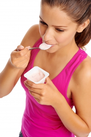 Healthy woman eating yoghurt isolated on whiteの写真素材