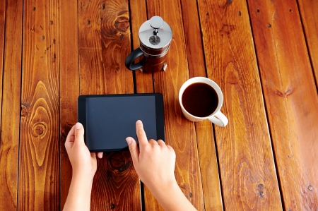 Young woman uses tablet while relaxing at home with coffee on the sofa couchの写真素材