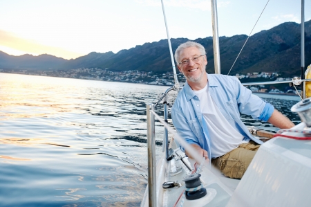 carefree happy sailing man portrait of mature retired man on ocean boat at sunrise