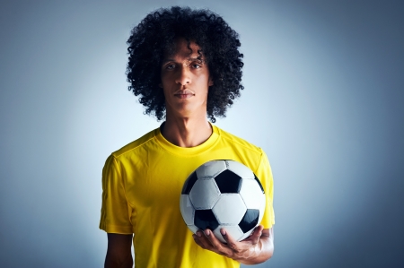 Portrait of Brazilian soccer football player with ball and national kit ready for the world cupの写真素材
