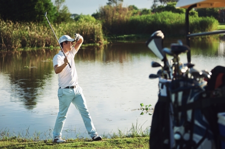 golf man shields eyes from sun to see where ball is. real golfer playing gameの写真素材