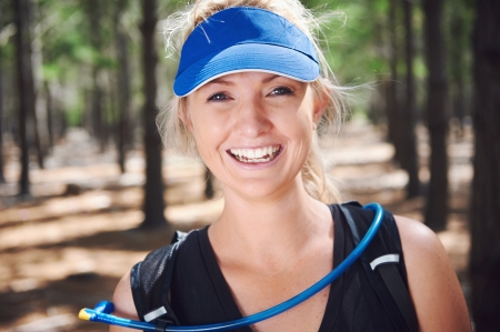 Happy fit healthy woman smiling while trail running