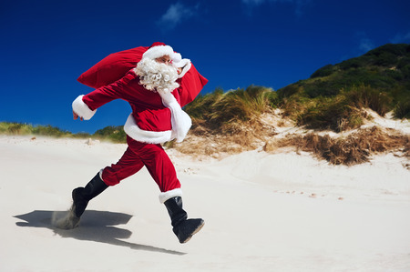 Santa Claus walking along the beach in an out of context situationの写真素材