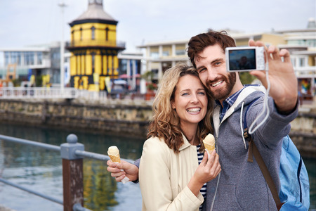 couple eating icecream taking selfie on holiday vacation travelの写真素材