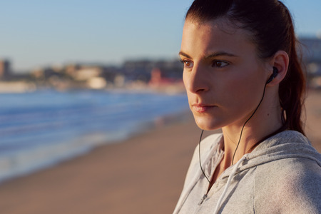 Portrait of healthy fitness woman before her morning running workout on beachの写真素材