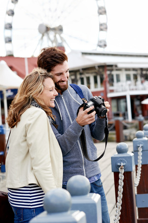 young couple taking pictures on holiday at tourist attractionの写真素材