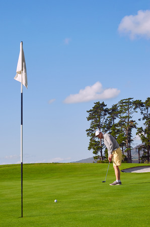 golfer playing on beautiful scenic course on summer vacationの写真素材