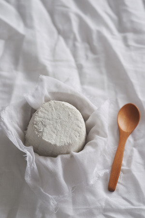 Soft homemade fresh ricotta cottage cheese made from milk, draining on muslin clothの写真素材