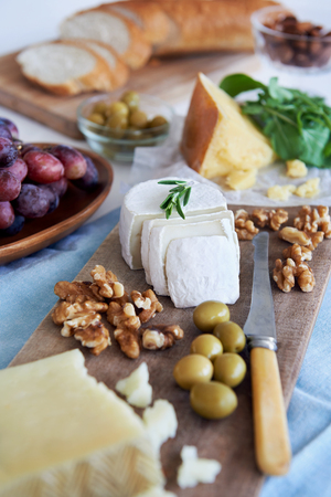Cheese platter starter appetiser pre dinner snack, assortment of different cheeses, nuts, olives and grapesの写真素材
