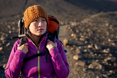 portrait of young asian woman hiking in Iceland with backpack and outdoor gear on vacationの写真素材