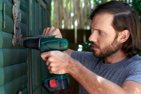 close up of young caucasian DIY male mounting plant standsの写真素材