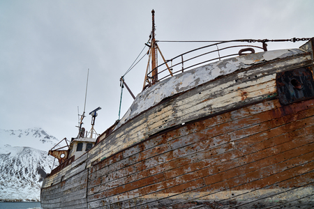 Commercial wooden fishing boat vessel in the dock in winterの写真素材