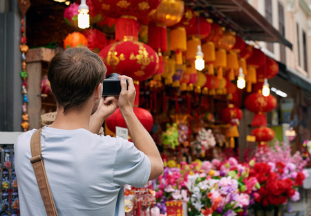 Solo traveler tourist taking photos of red colourful shop store decorations for chines new year in modern asian cityの写真素材