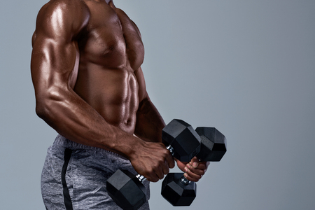Muscular black african man with well defined ripped muscles abs adominal lifting weightsの写真素材