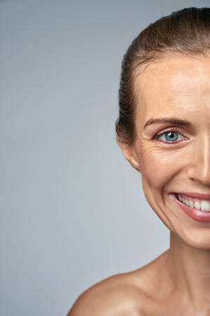 Close up portrait of smiling woman in her 30s, showing fine wrinkles and agingの写真素材
