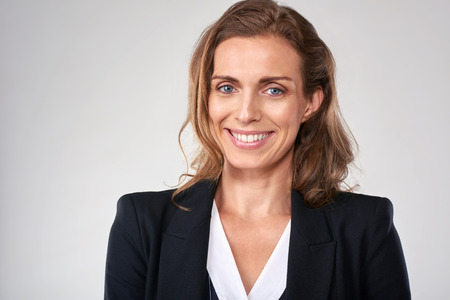 Headshot of middle age business woman in studio, isolated on greyの写真素材