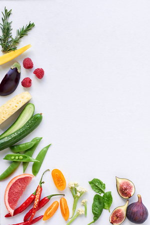 Food background border frame of colorful fresh produce raw vegetables, corn carrot chilli cucumber purple cabbage spinach rosemary herb, plenty of copy-spaceの写真素材