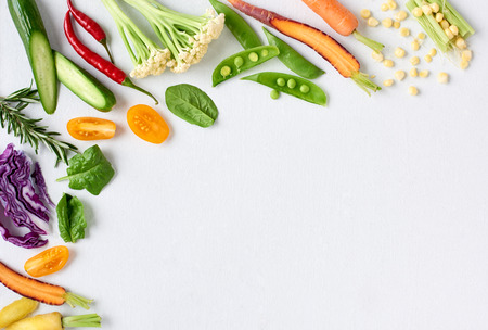 Food background border frame of colorful fresh produce raw vegetables, corn carrot chilli cucumber purple cabbage spinach rosemary herb, plenty of copy-spaceの写真素材