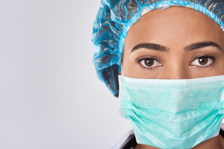 Close up of confident female surgeon in mask getting ready for medical procedure surgeryの写真素材