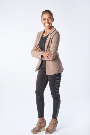 Full length portrait of mixed race business woman smiling in studio isolated on greyの写真素材