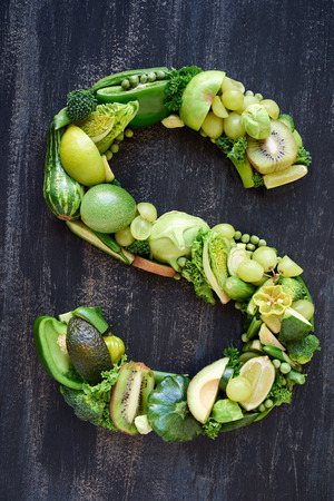 complete collection of alphabet letters made from healthy green fruit and vegetables on rustic distressed texture, overhead flat layの写真素材