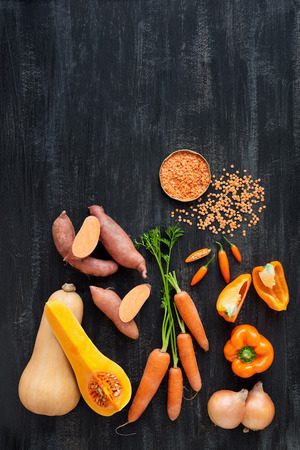 Raw organic produce vegetables for butternut soup, orange coloured food on dark backgroundの写真素材