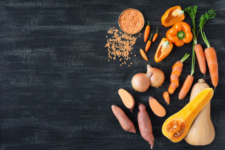 Raw organic produce vegetables for butternut soup, orange coloured food on dark backgroundの写真素材
