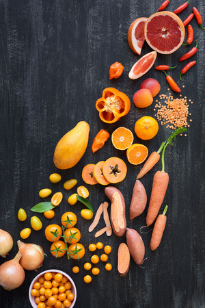Color spectrum of vibrant raw produce fruit and vegetables from yellow orange to redの写真素材