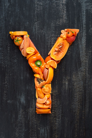 orange hued collection of  raw produce shaped to letters of alphabet, poster design elementの写真素材