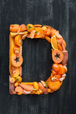 complete collection of alphabet letters made from healthy orange fruit and vegetables on rustic distressed texture, overhead flat layの写真素材