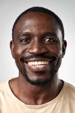 Happy smiling african black man portrait of real person in studio. full collection of diverse faces in this set.の写真素材
