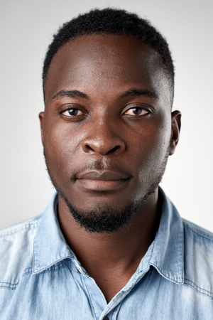Portrait of real black african man with no expression ID or passport photo full collection of diverse face and expressionsの写真素材