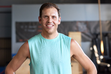 Portrait of fit healthy man happy in sportswear smiling in gym, fitness lifestyle conceptの写真素材