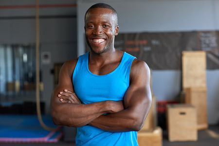 Smiling portrait of happy black african man in sportswear in a gymの写真素材