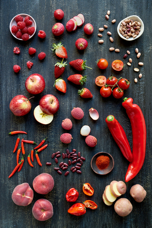 Overhead series of assorted red toned vegetables, fresh organic raw produce flat layout backgroundの写真素材