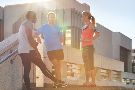 Diverse group of friends meeting up and talking before their exercise fitness session in the cityの写真素材