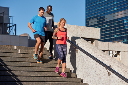 Multi ethnic racial people running between modern office buildings, healthy lifestyle work life balanceの写真素材