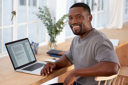 Successful black business man smiling to camera while working from home, modern working structureの写真素材
