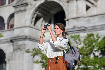 Woman taking pictures while traveling on vacationの写真素材