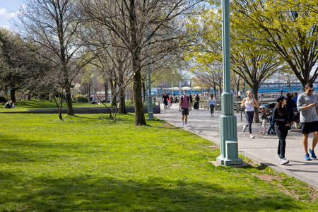 New York, NY, USA - July 1, 2021: Walkers and joggers enjoying a spring day on the Hudson River Greenwayのeditorial素材
