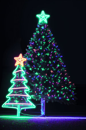 Dark christmas tree illuminated with neon lights on dark background, wallpaper christmas banner Ai Generatedの素材