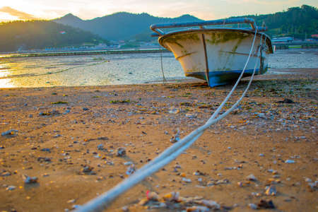 boat tied from the rope in the beach water gone to outのeditorial素材